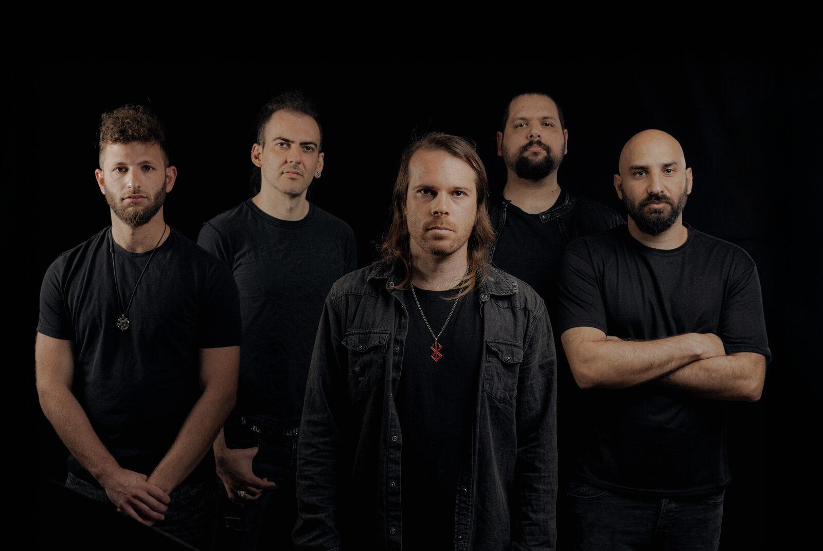 Os cinco integrantes da No-mad, banda de metal progressivo de Israel, em retrato de estúdio com fundo preto